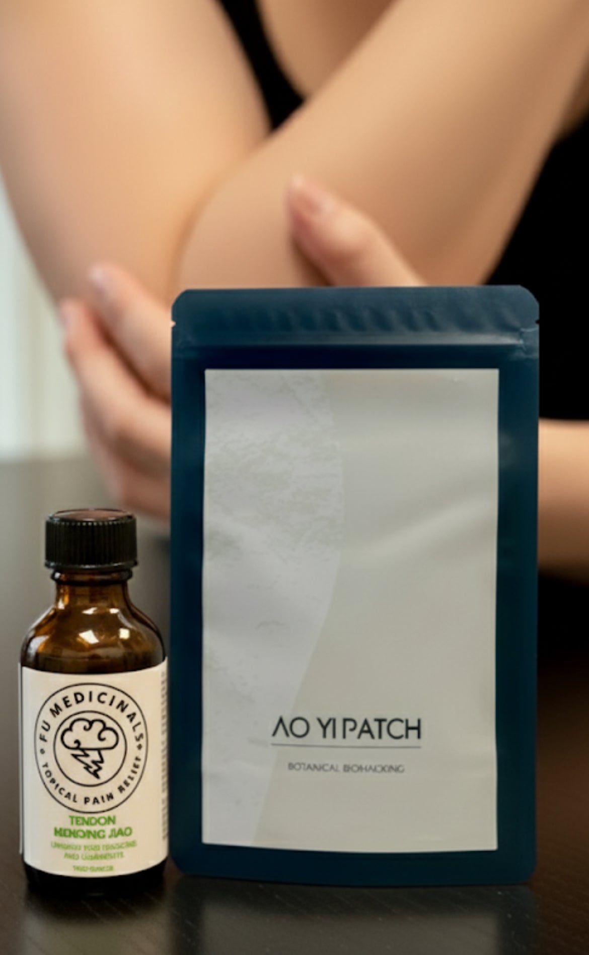 Bottle of 'AO YI PATCH' and its packaging on a reflective surface.