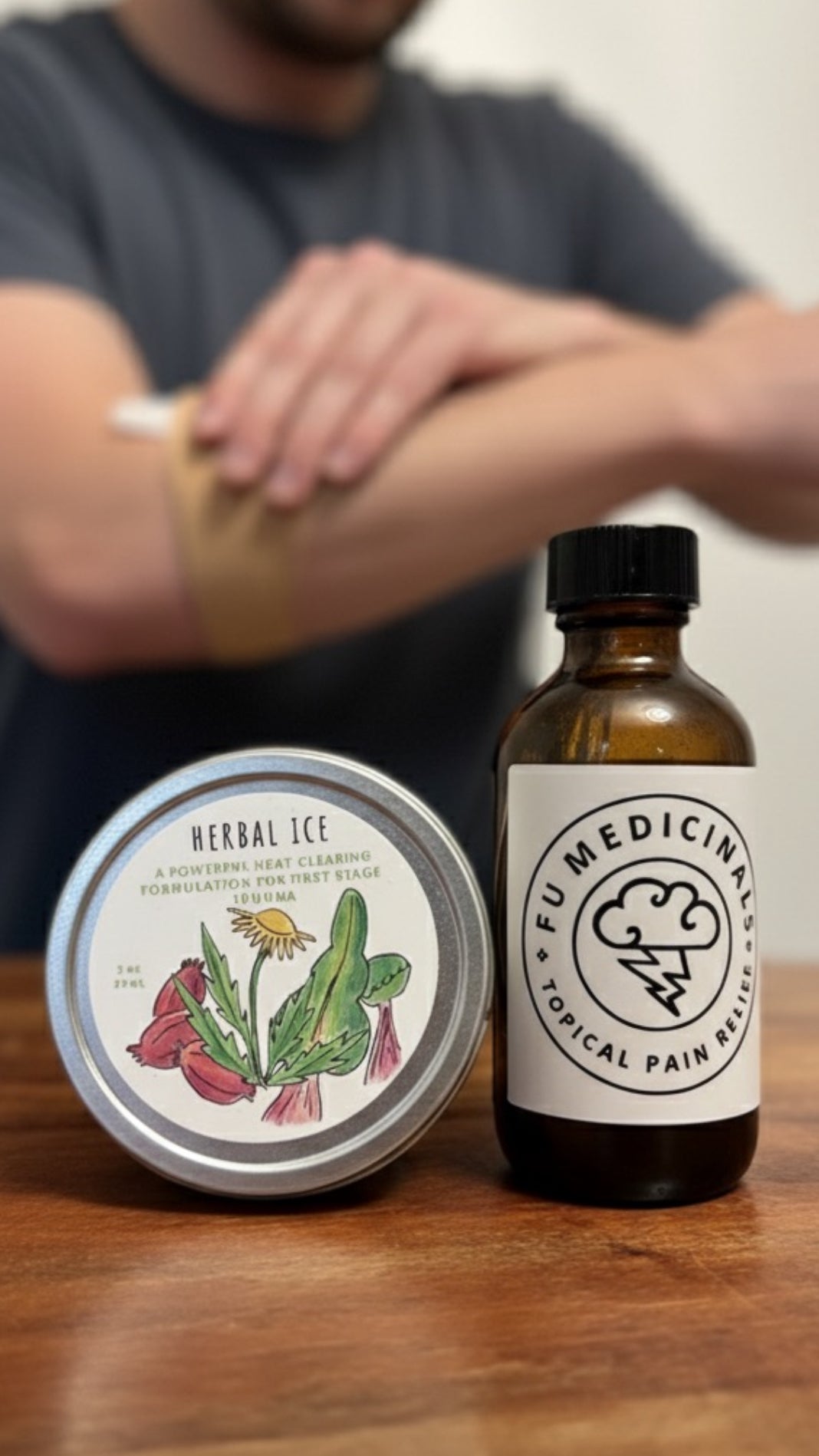 Herbal Ice cream and bottle of Fu Medicinal Topical Pain Relief on a wooden surface with a person applying cream to their arm.