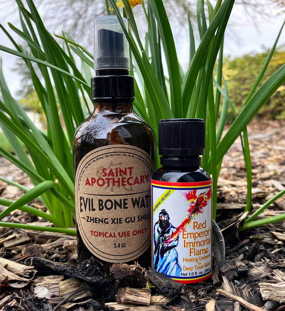 Two bottles of Saint Apothecary and Red Emperor Immortal Flame products on a natural background.