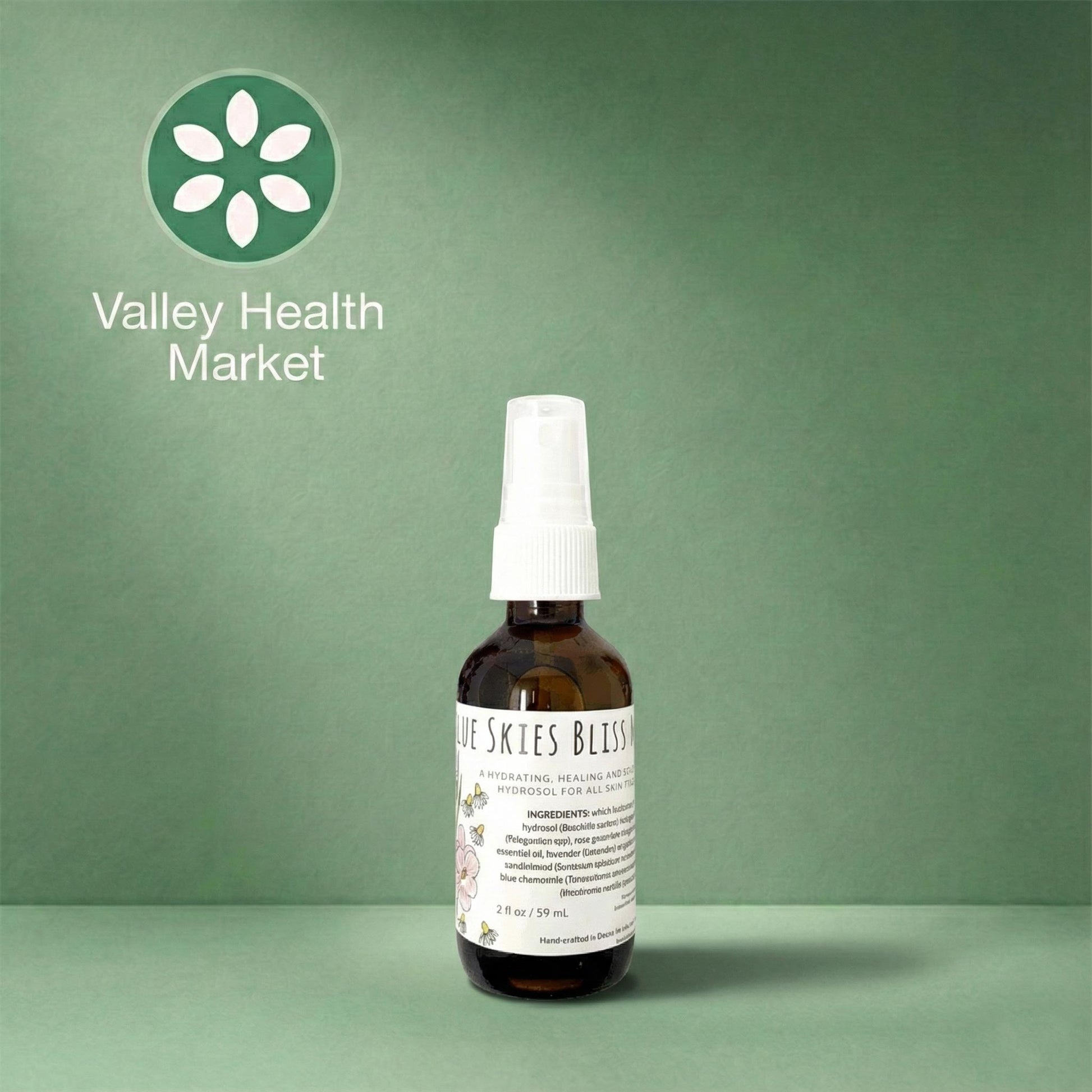 Bottle of Blue Skies Bliss Mist spray with a white label on a green background, featuring Valley Health Market logo.