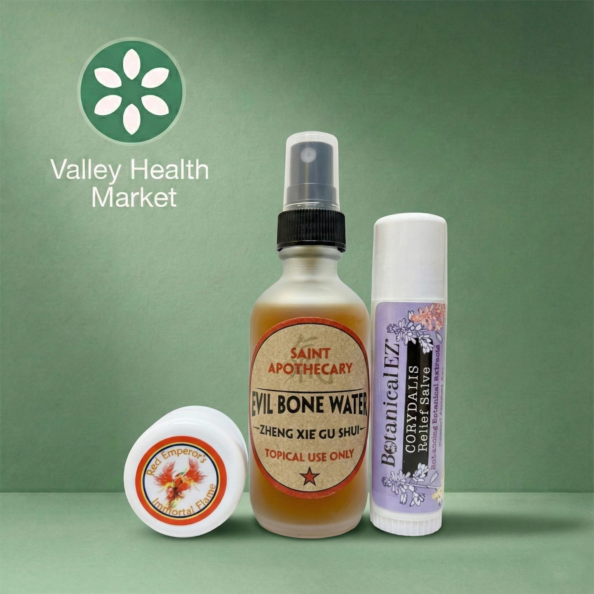 Red Emperor's Immortal Flame, Evil Bone Water and Corydalis Relief Salve sample sizes with labels on a green background, featuring the Valley Health Market logo.
